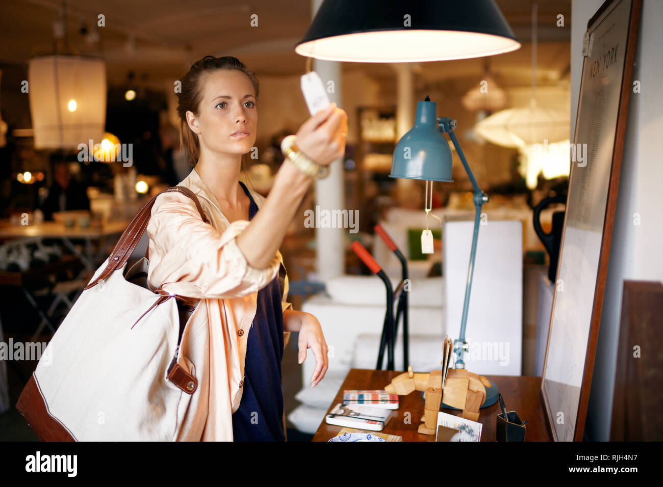 Woman looking at lamp in shop Stock Photo