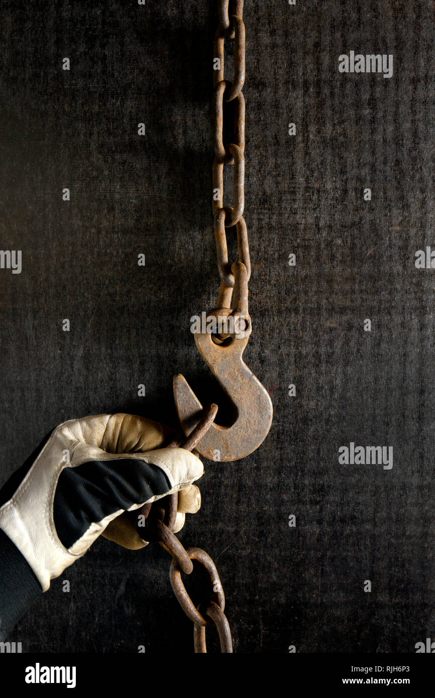 Hand putting chain on hook Stock Photo Alamy