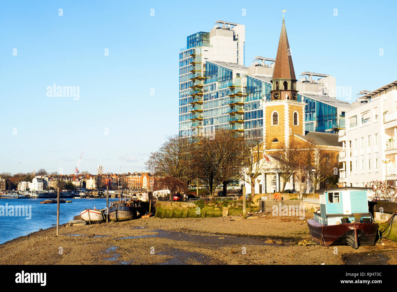 Boats moored at low tide on The River Thames near Saint Mary's Church, Battersea, Wandsworth - South West London, england Stock Photo