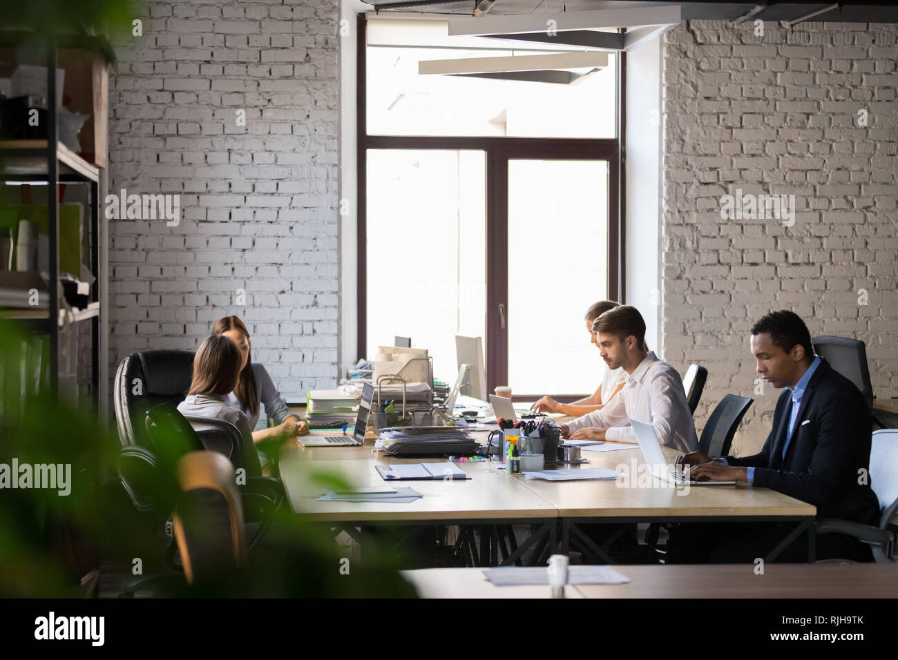 Diverse employees busy working in shared office  Stock Photo