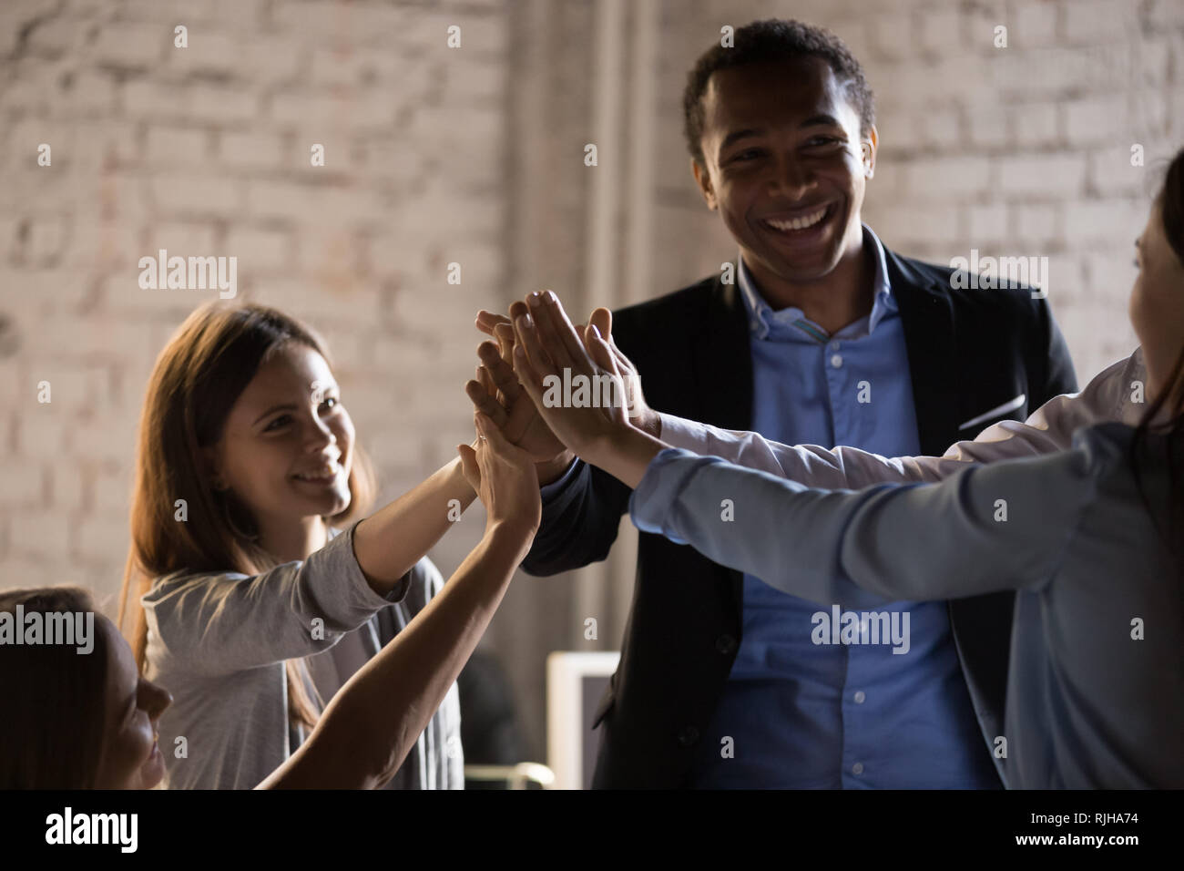 Diverse colleagues give high five celebrating business success Stock ...