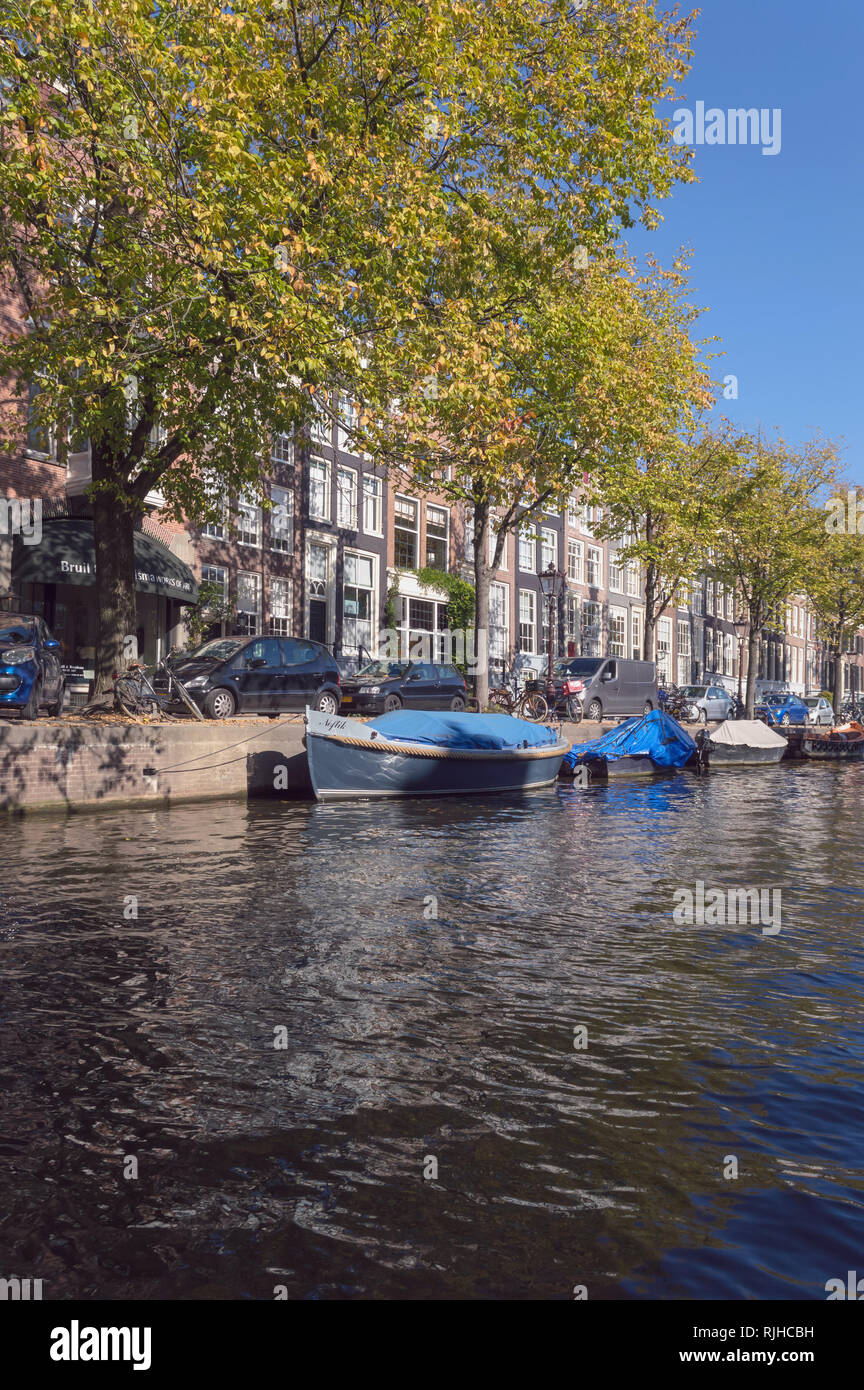 Amsterdam, The Netherlands, October 10, 2018: view from canal on cars parked at narrow street with trees Stock Photo