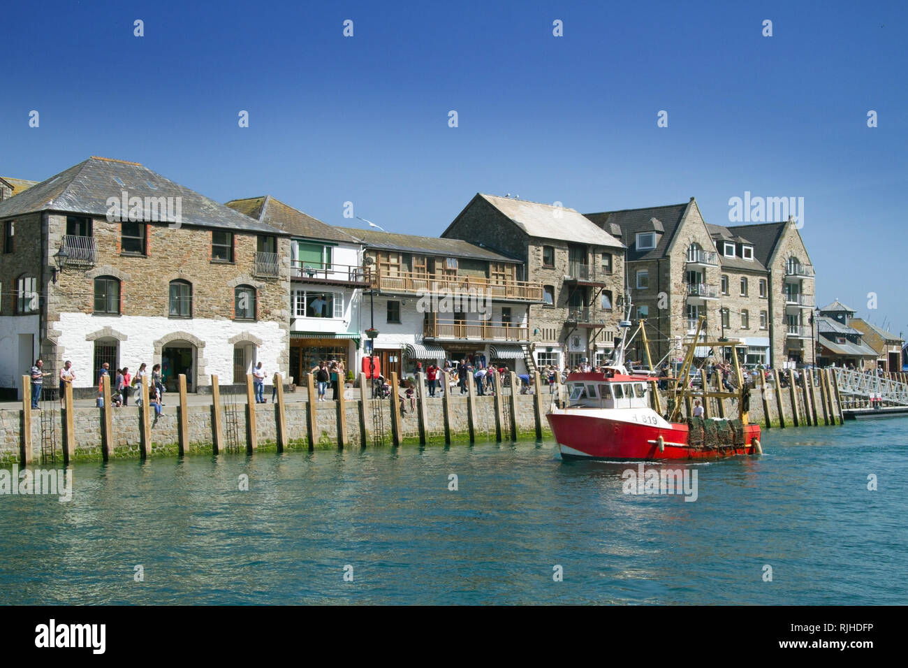 Red fishing boat returns to harbour at Looe Cornwall. Seaside town and commercial centre Stock Photo
