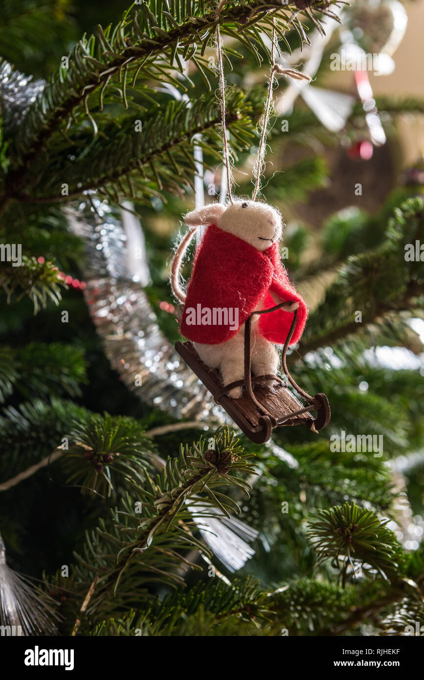Mouse in a red cloak sledging, Christmas tree ornament Stock Photo