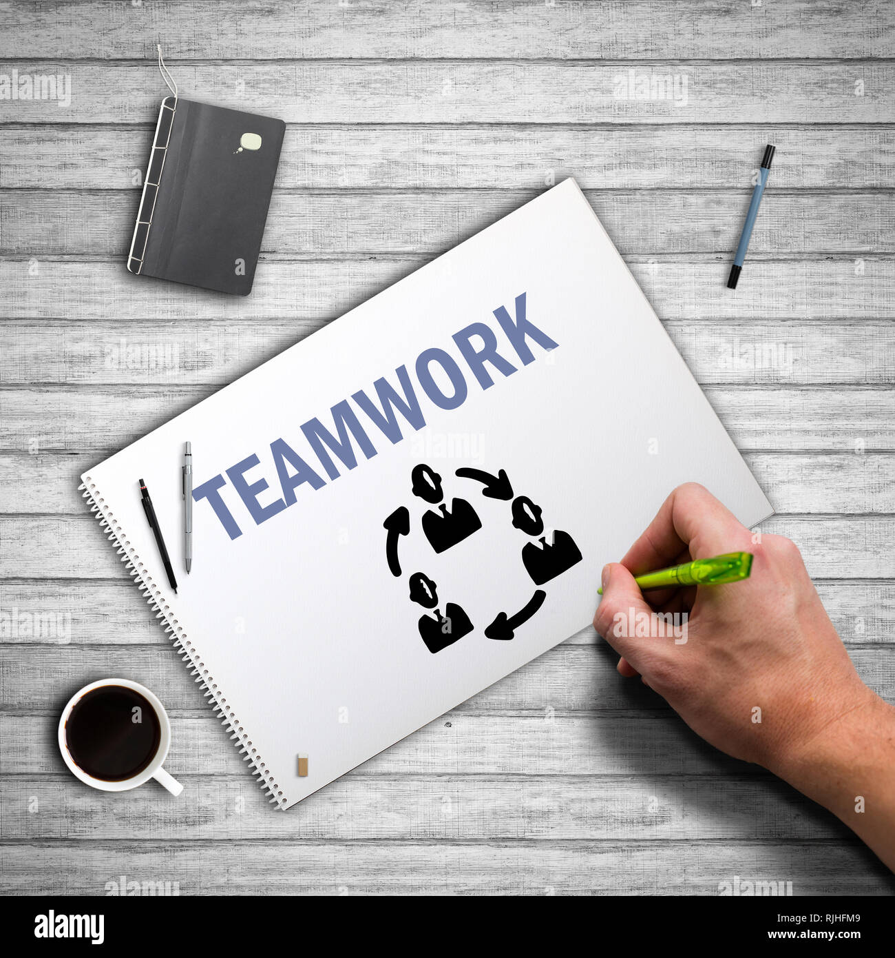 hand writing a teamwork concept on notepad on wooden background Stock ...