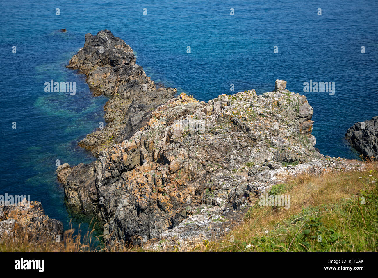 Rock outcrop showing clarity of the sea on the Alderney coast near Roselle Point. Stock Photo