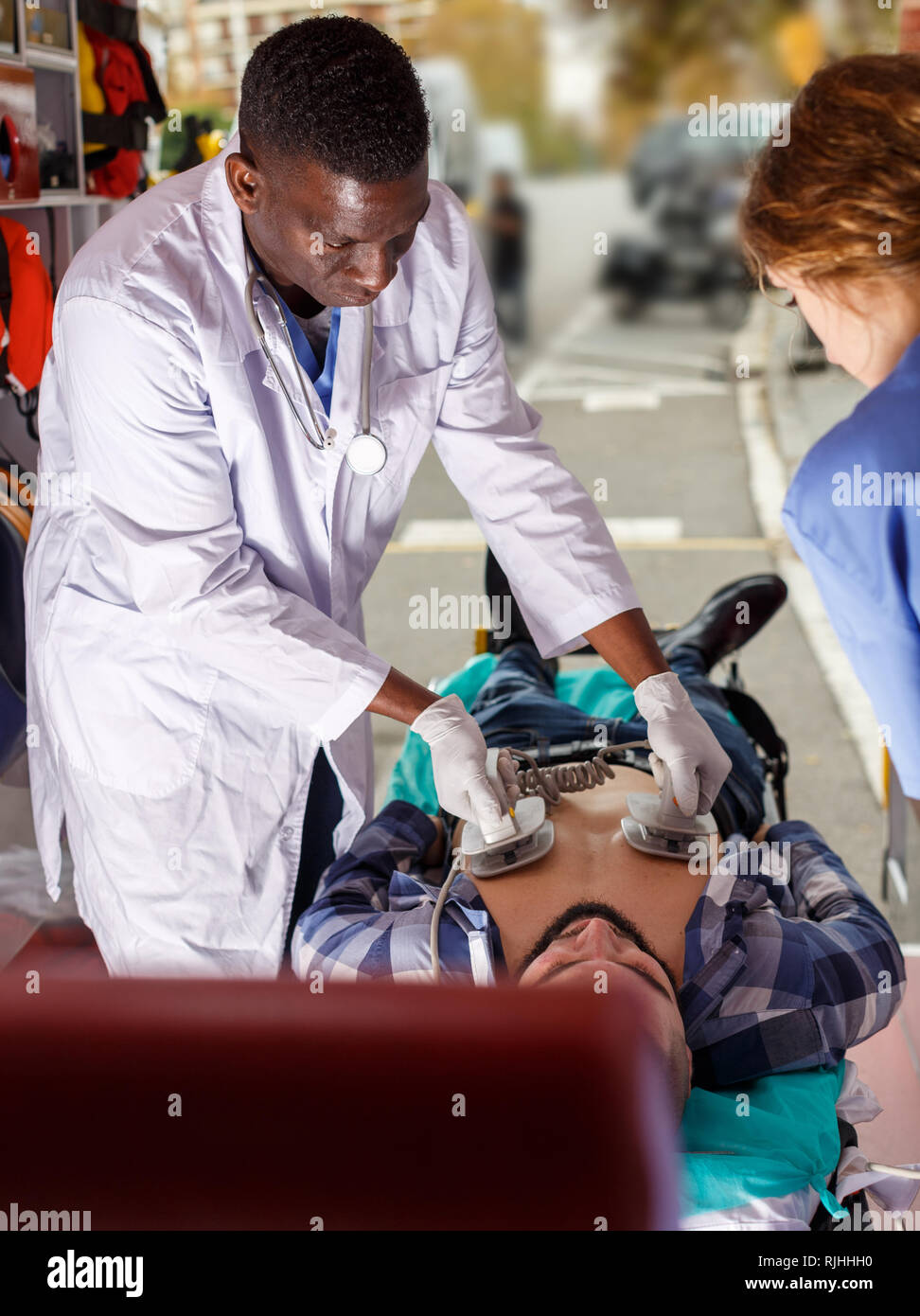Rescue team making defibrillation to patient in ambulance car Stock ...