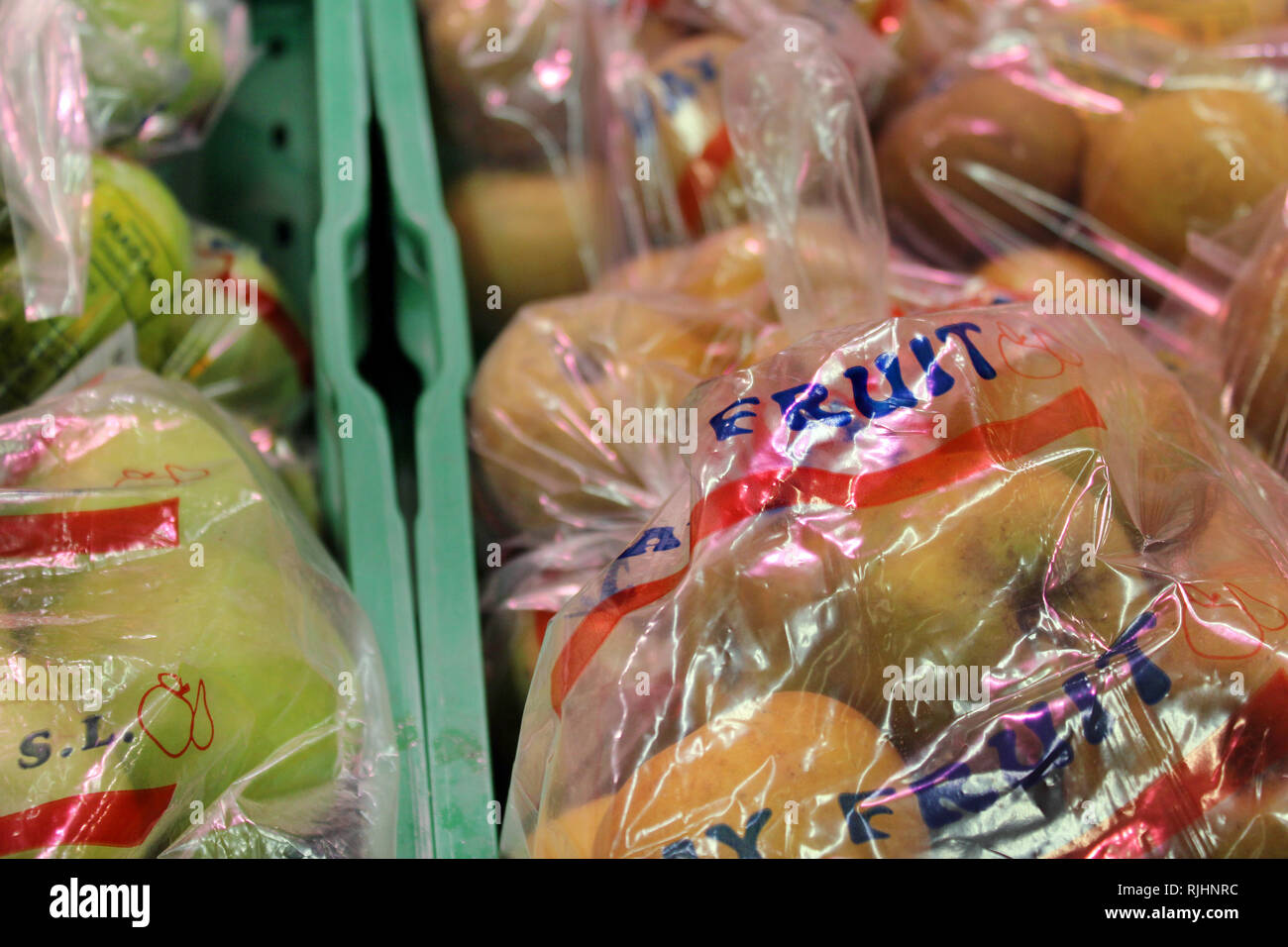 Display of fruits wrapped in plastic bags on a supermarket Stock Photo