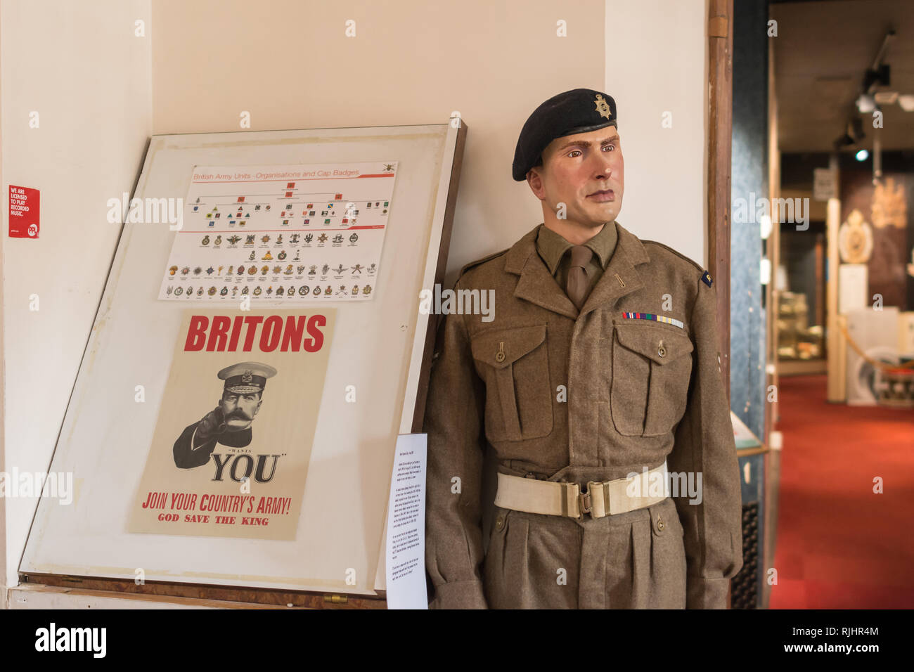 Inside Aldershot Military Museum - model of a soldier beside an old world war I vintage army recruitment poster with Lord Kitchener Stock Photo