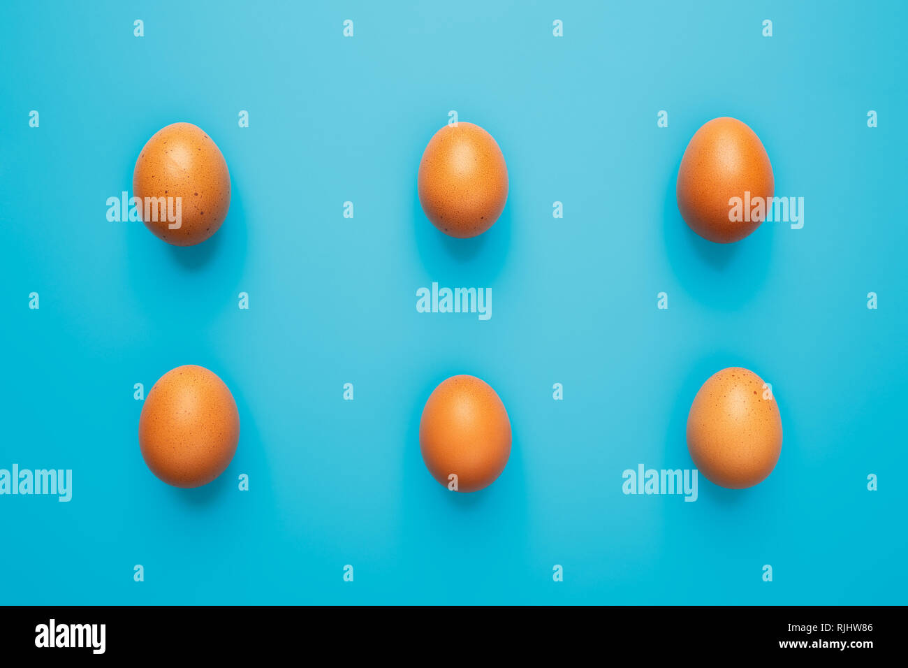 Six brown eggs on blue turquoise background, top view with copy space Stock Photo