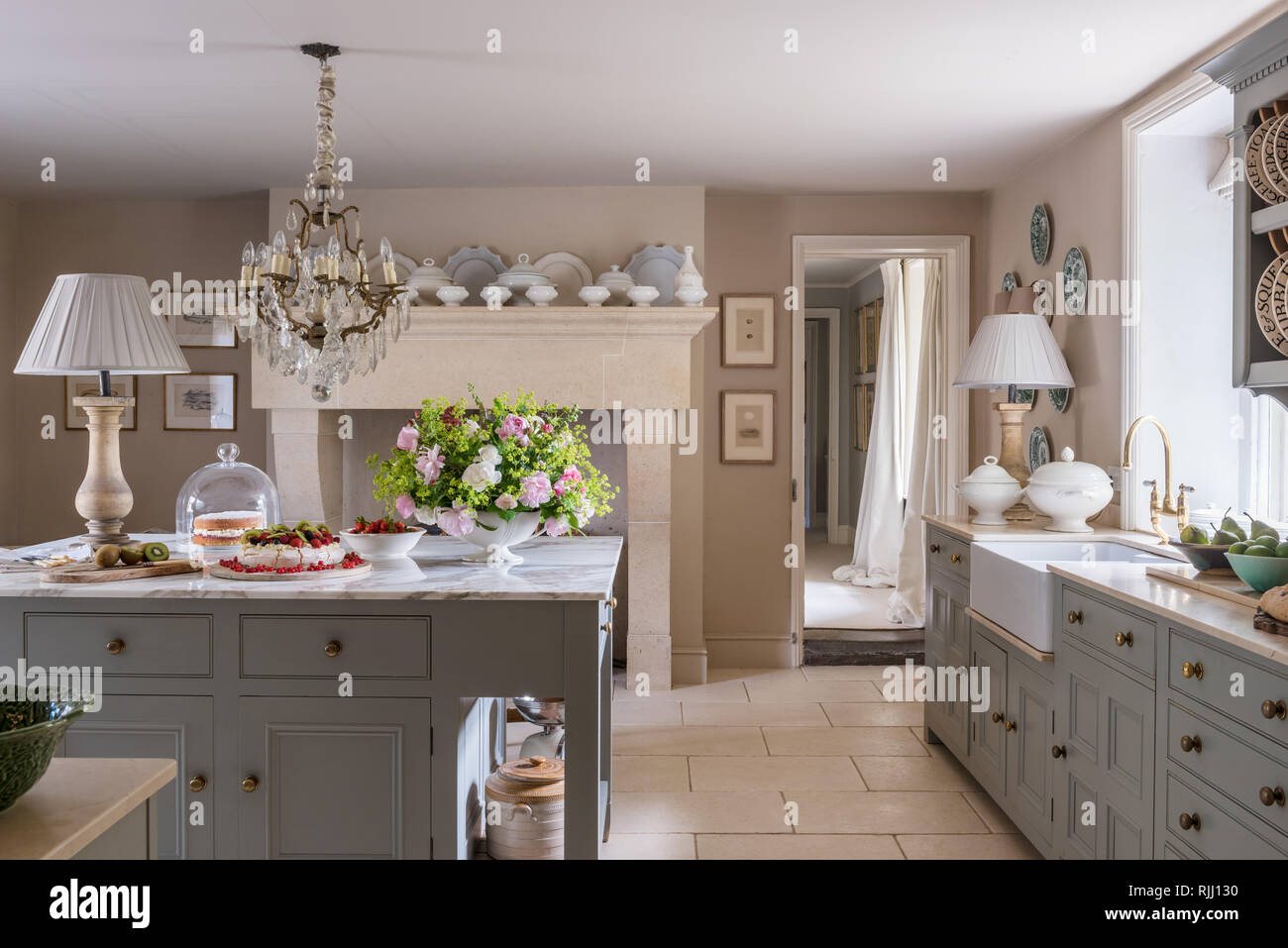 Bespoke cabinets from Mark Goodacre Kitchens painted in  50/50 mix of Farrow & Ball’s Hardwick White and Pigeon. The flooring is from Mandarin Stone. Stock Photo