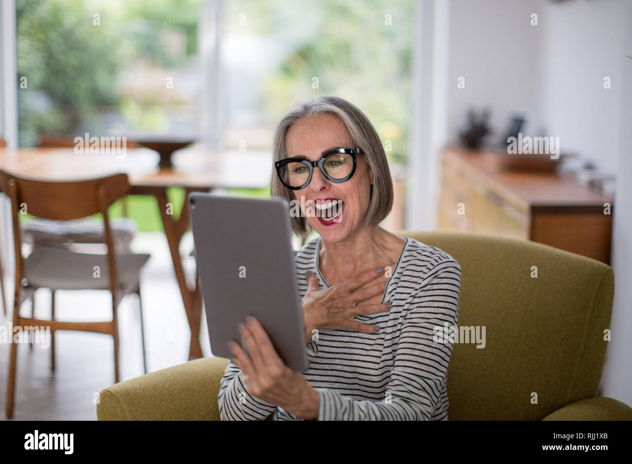 Mature adult female on a videocall to family Stock Photo