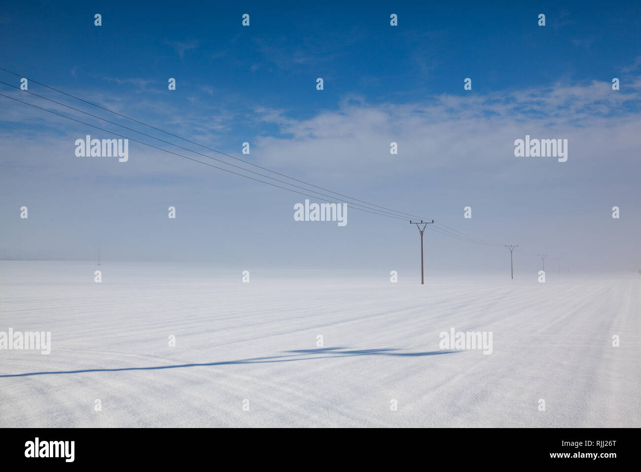 Winter landscape with power line columns  a snow covered field. Stock Photo