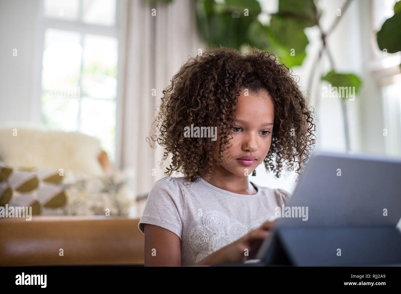 African American girl using digital tablet for homework Stock Photo