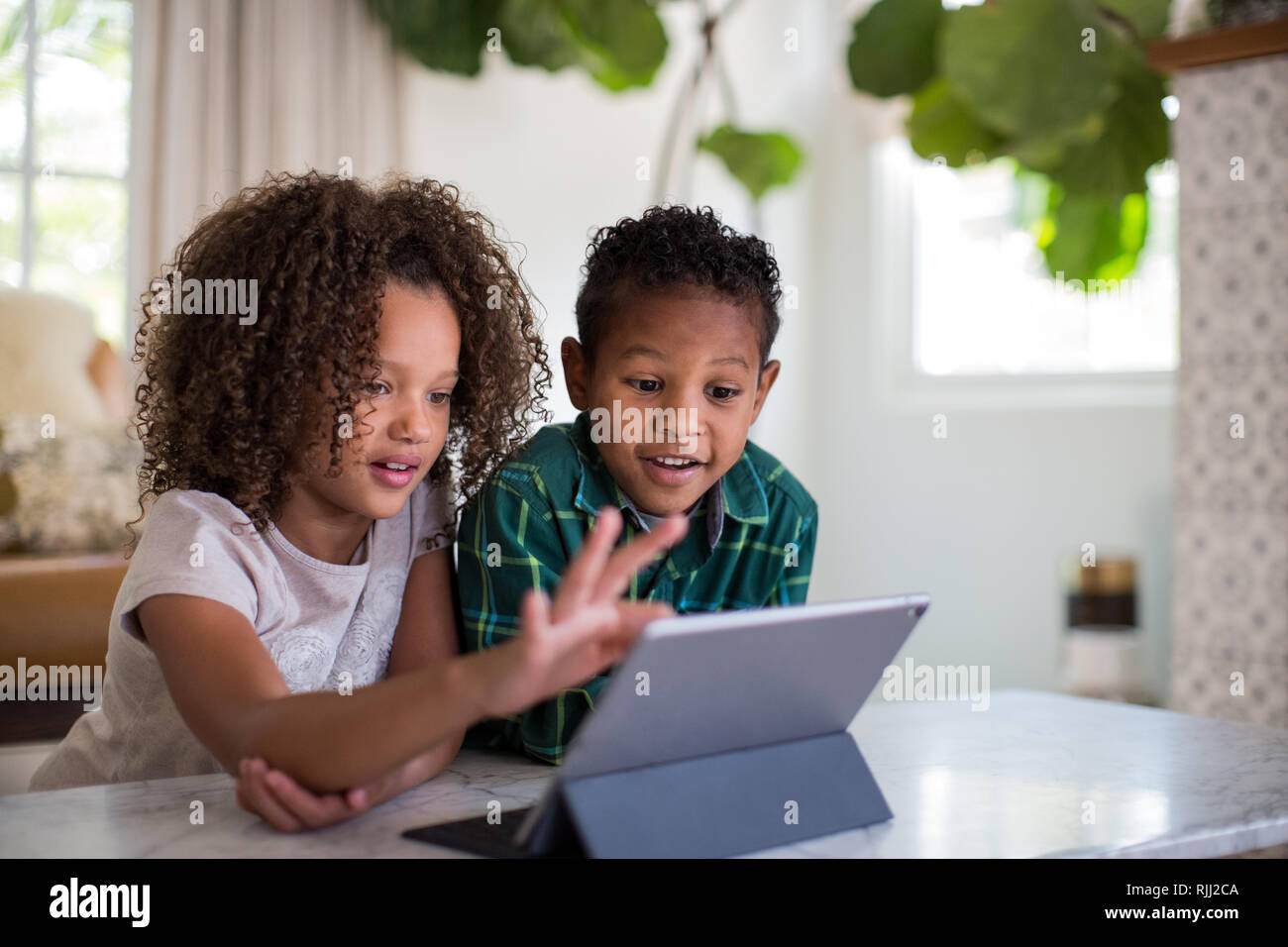 African American brother and sister playing together on digital tablet Stock Photo