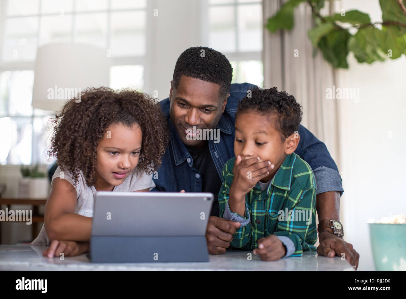 African American family using digital tablet together Stock Photo
