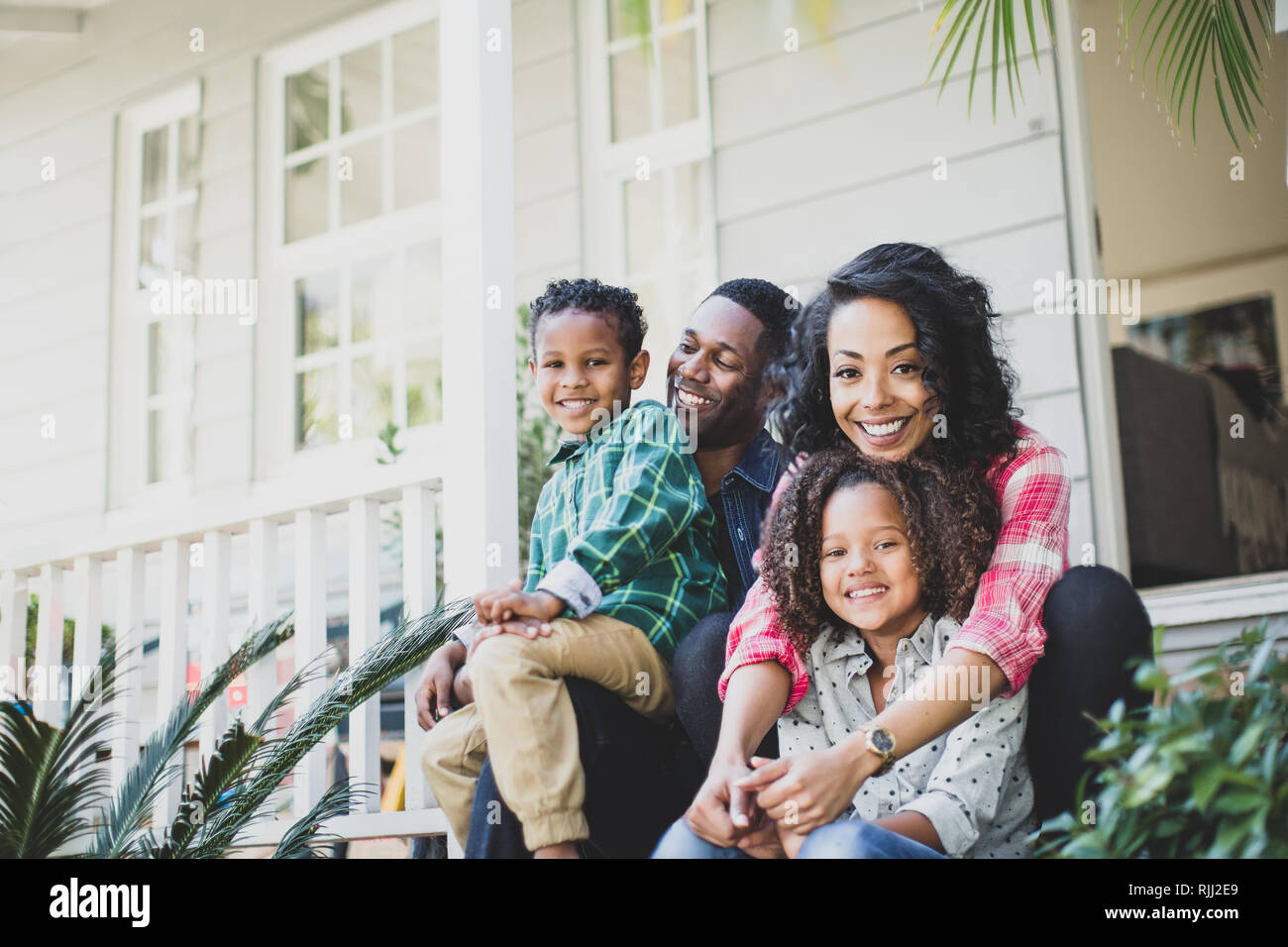 Portrait of African American family sitting outside home Stock Photo