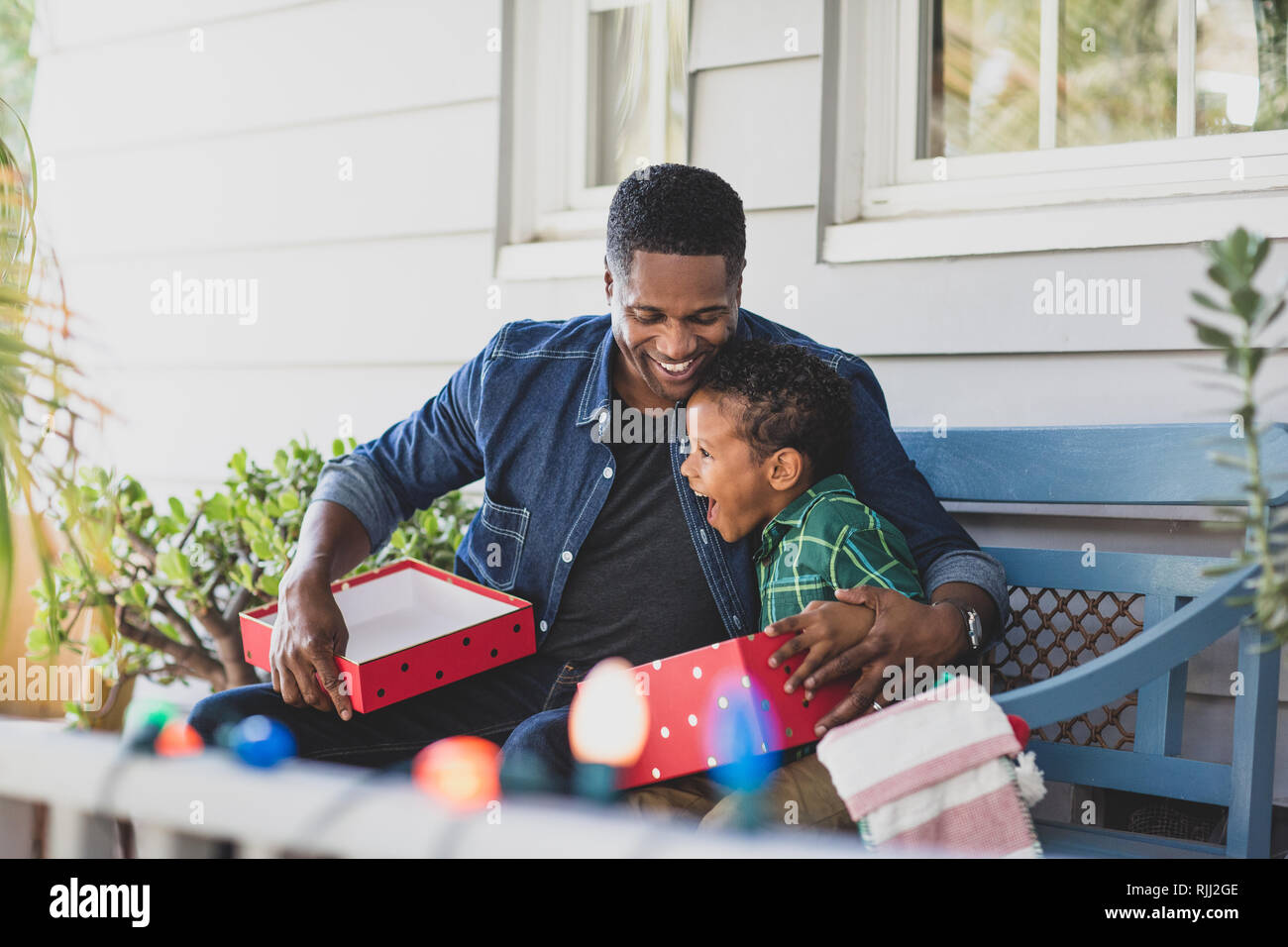 African American father giving son a christmas gift Stock Photo