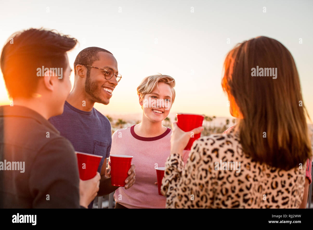 Group of friends gathering on a rooftop for a celebration Stock Photo