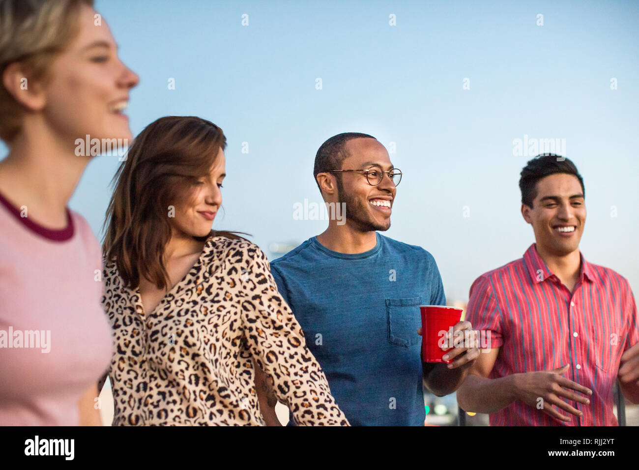 Group of friends dancing at a rooftop party Stock Photo
