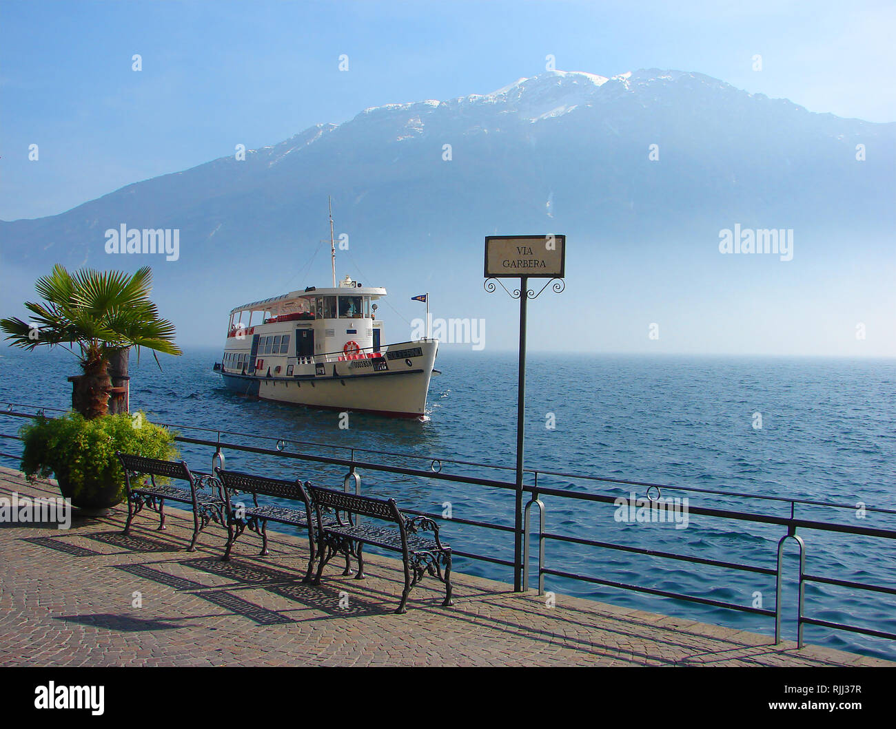 2014 - The launch 'Solferino' arrives  on misty Lake Garda at Via Garbera, Limone sul Garda (Limones / Limone / Limu), in the province of Brescia, in Lombardy (northern Italy). Stock Photo