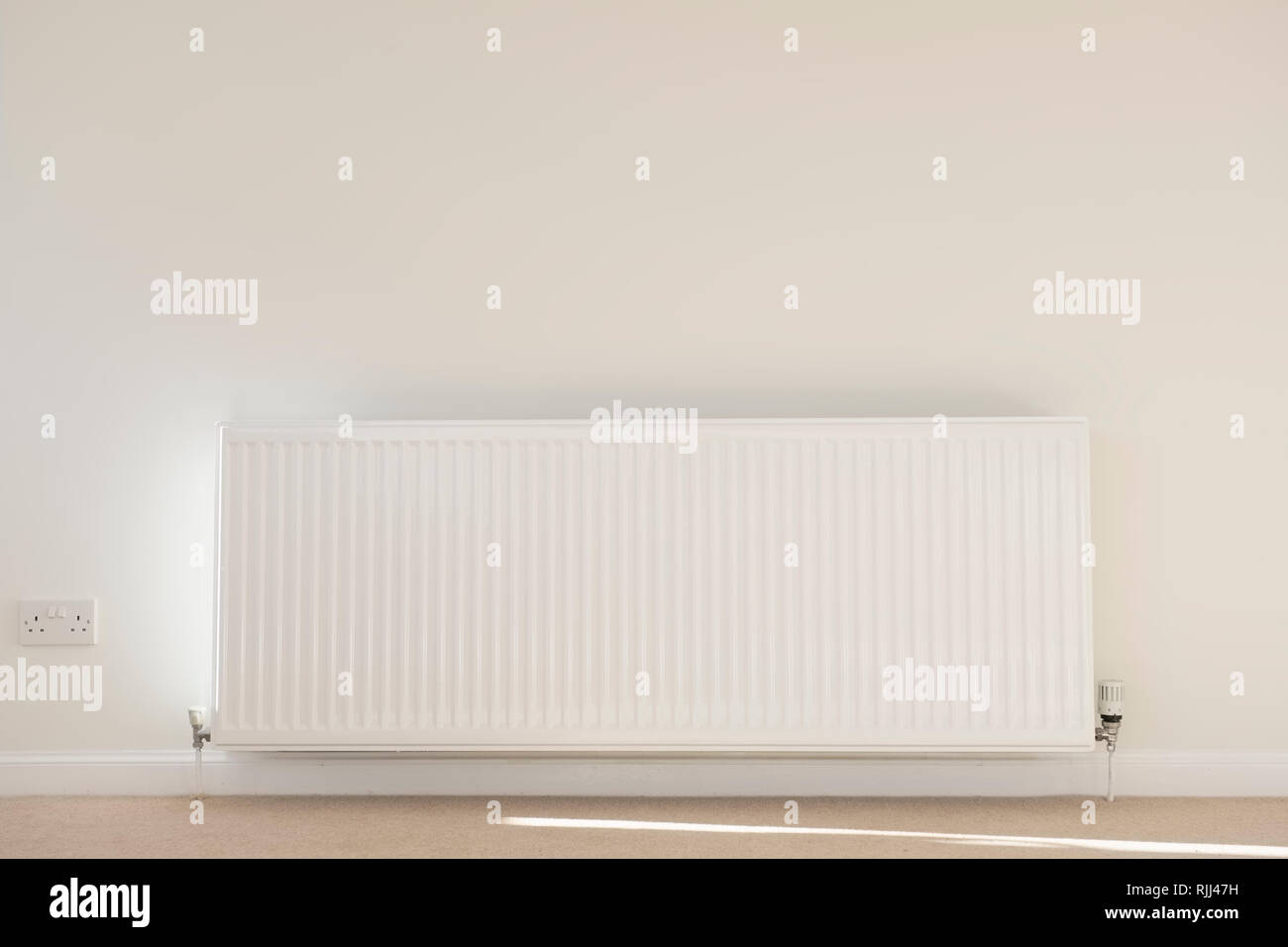 One single radiator single white in lounge neutral background carpet ...
