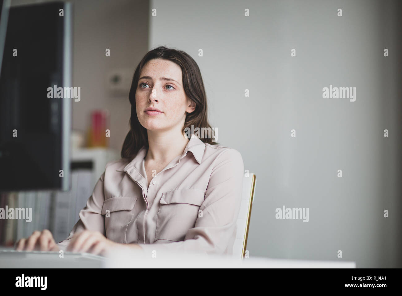 Female business executive working in an office on a desktop computer Stock Photo