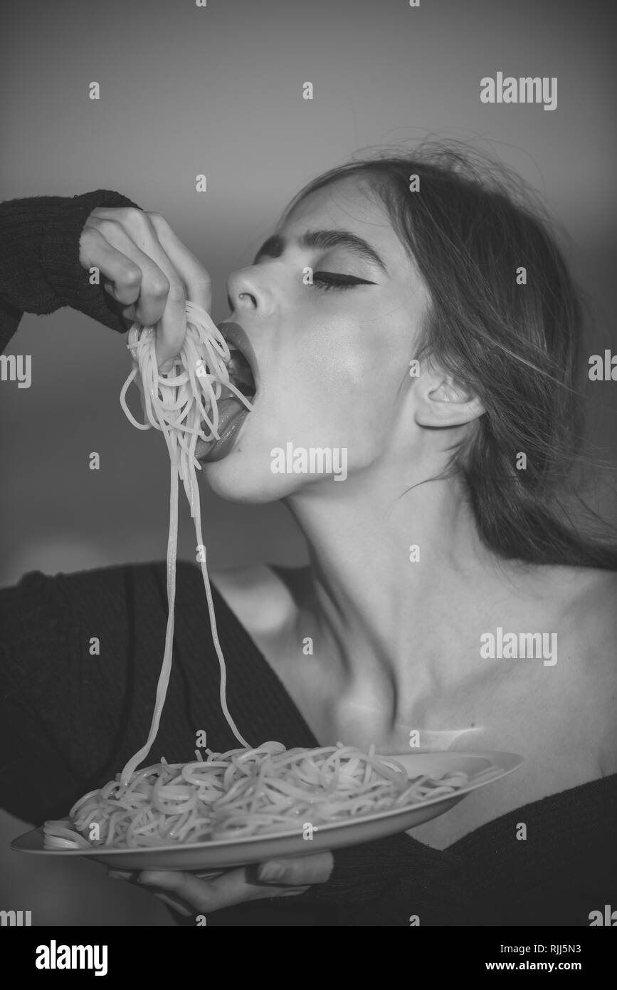 Hunger, appetite, recipe. Diet and healthy organic food, italy. Woman eating pasta as taster or restaurant critic. Chef woman with red lips eat pasta Stock Photo