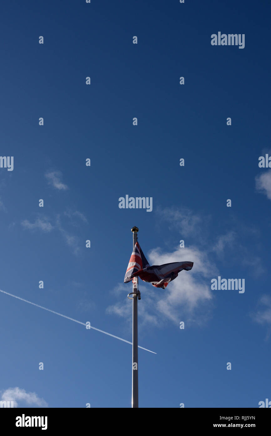 Union jack flag fluttering in the breeze with blue sky background in ...