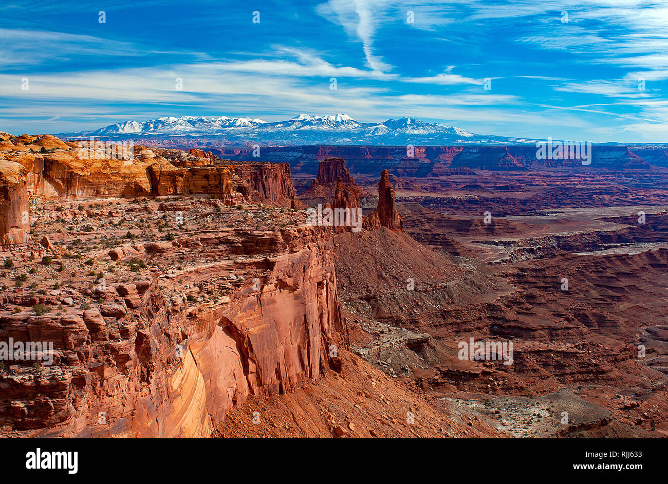 January 2019: The red sandstone canyon walls of Island in the Sky lead toward the snow capped peaks of the La Sal Mountain Range, Canyonlands National Stock Photo