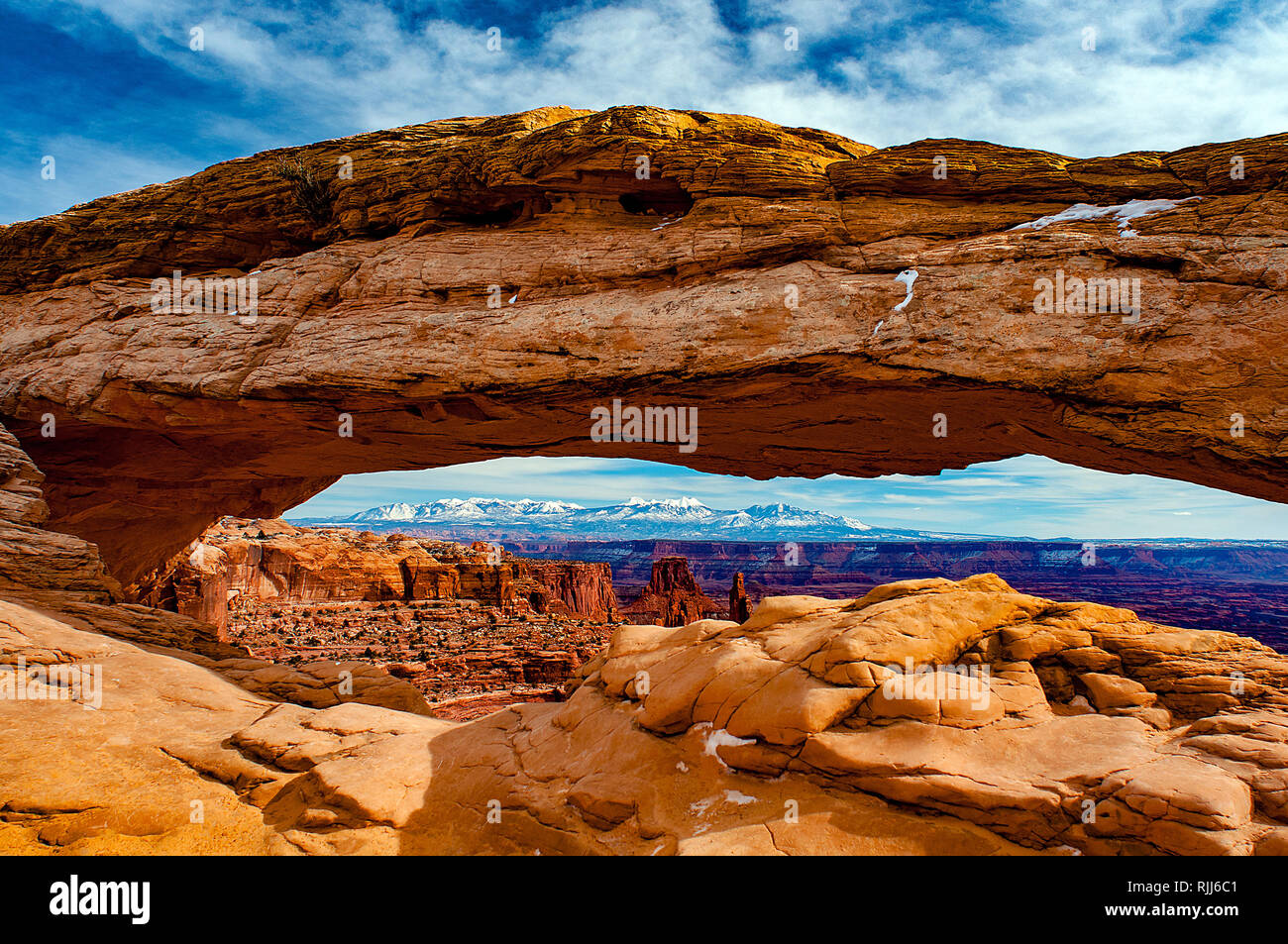 January 2019: Canyonlands National Park's Mesa Arch provides a beautiful sandstone frame for the snowcapped La Sal Mountains near Moab, Utah. Stock Photo