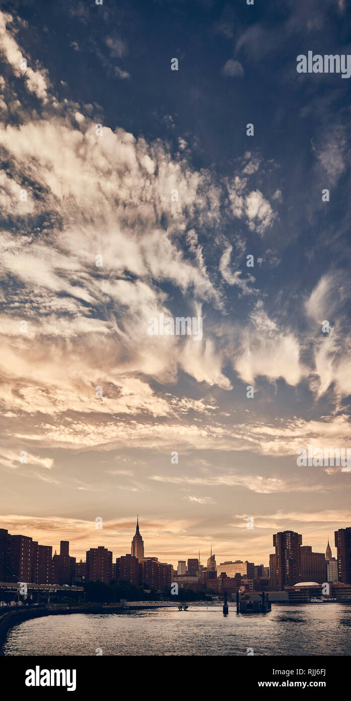 Manhattan skyline silhouette with dramatic cloudscape at sunset, color toned picture, New York City. Stock Photo