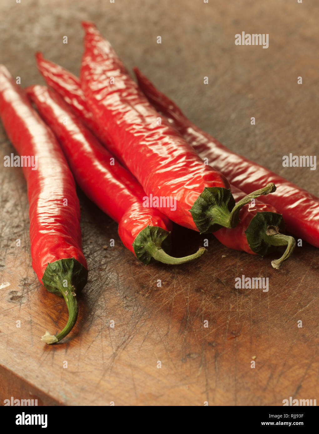 Red chilly peppers on a timber board Stock Photo - Alamy