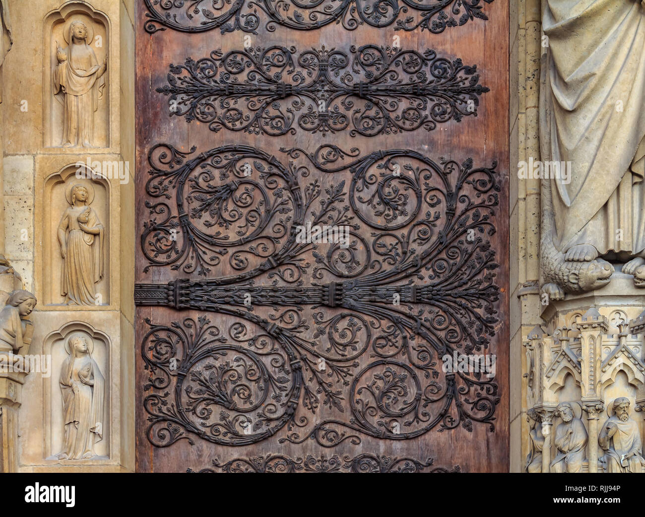 Intricate vintage wrought iron scroll work on the hinges on the doors on the facade of Notre Dame de Paris Cathedral in Paris France forged metal hing Stock Photo