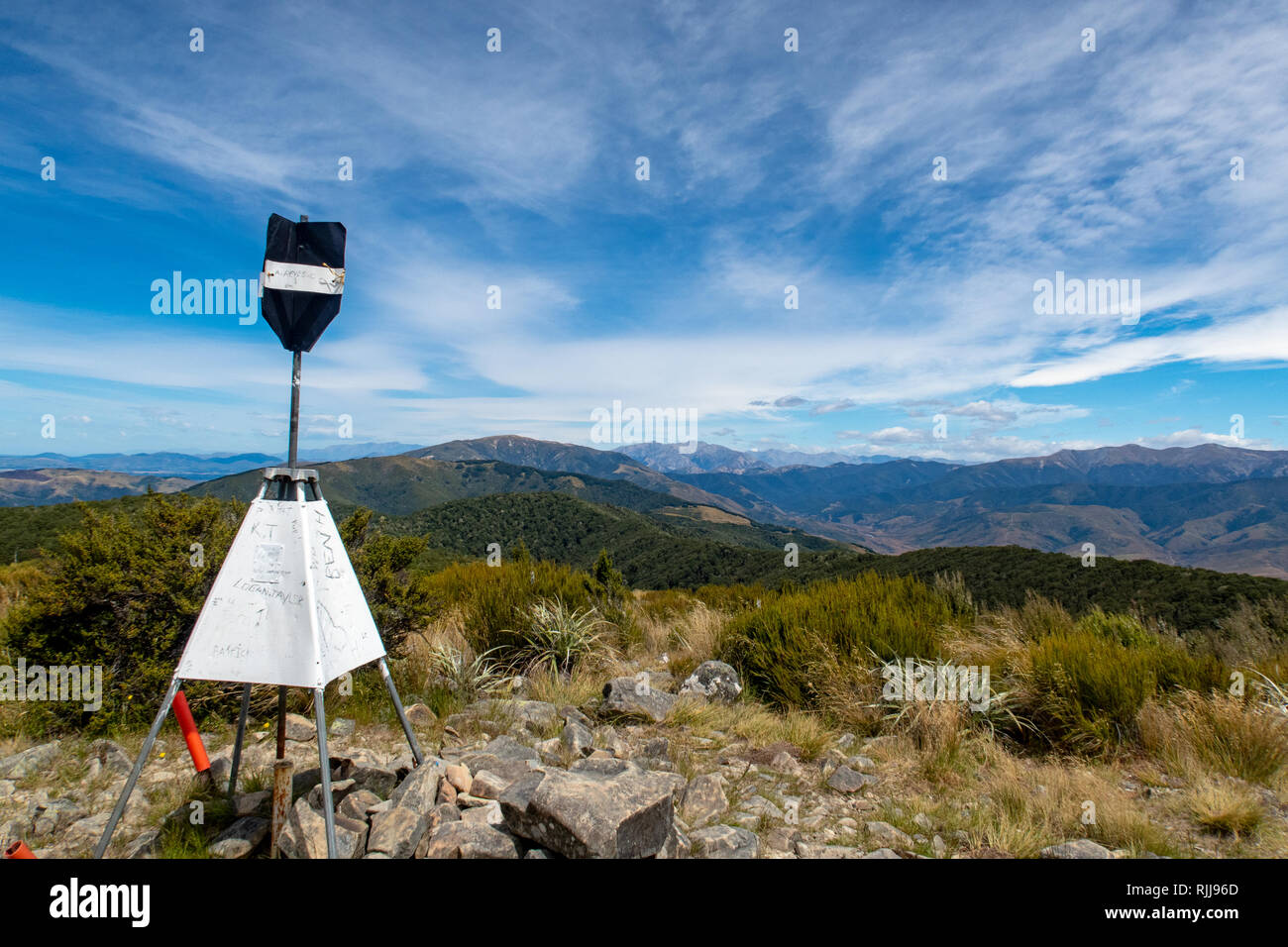 The trig station at the summit of Mt Richardson with a view of the surrounding mountains, New Zealand Stock Photo