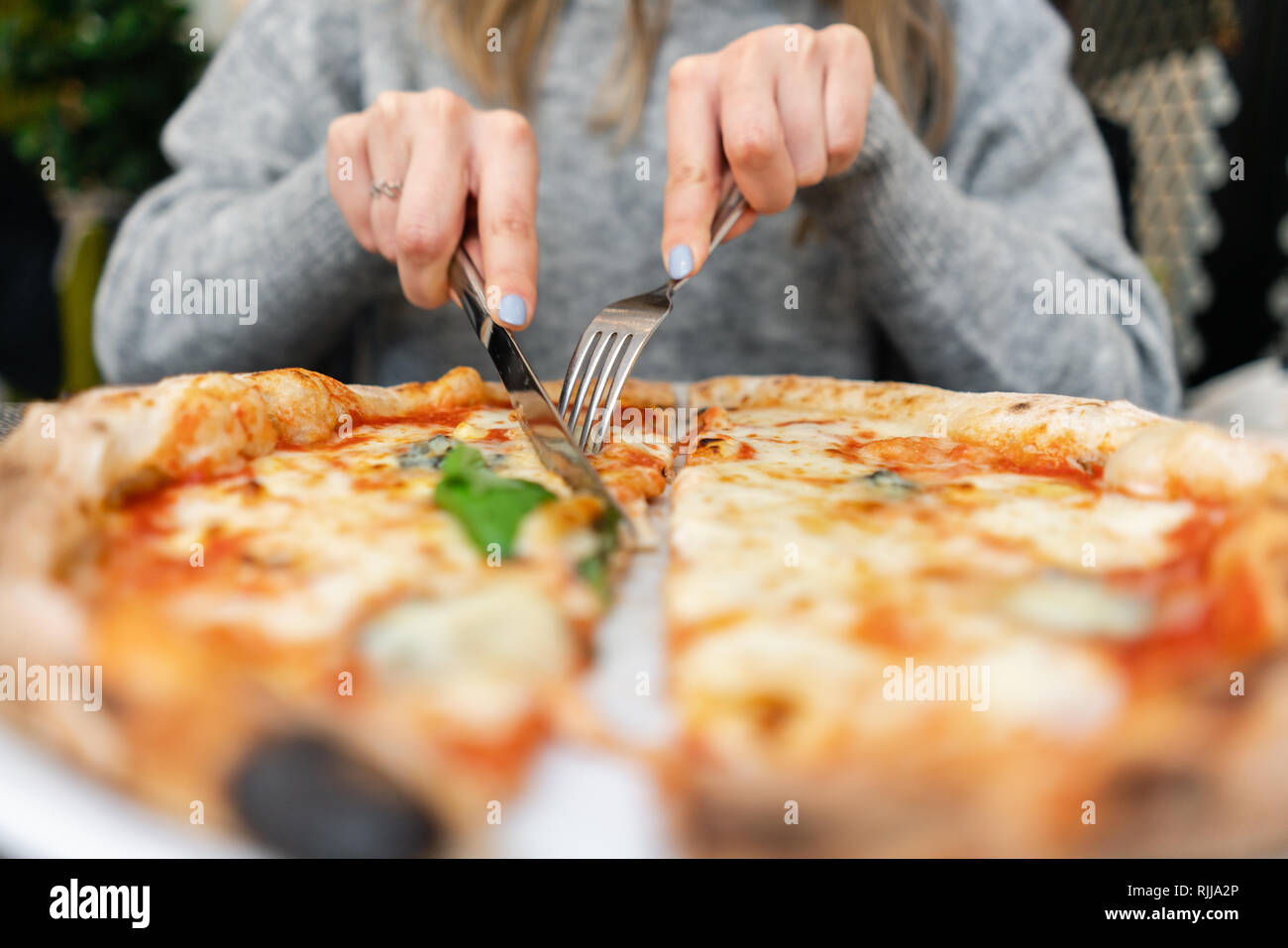Woman Eats With Knife And Fork A Pizza Margherita With Mozzarella