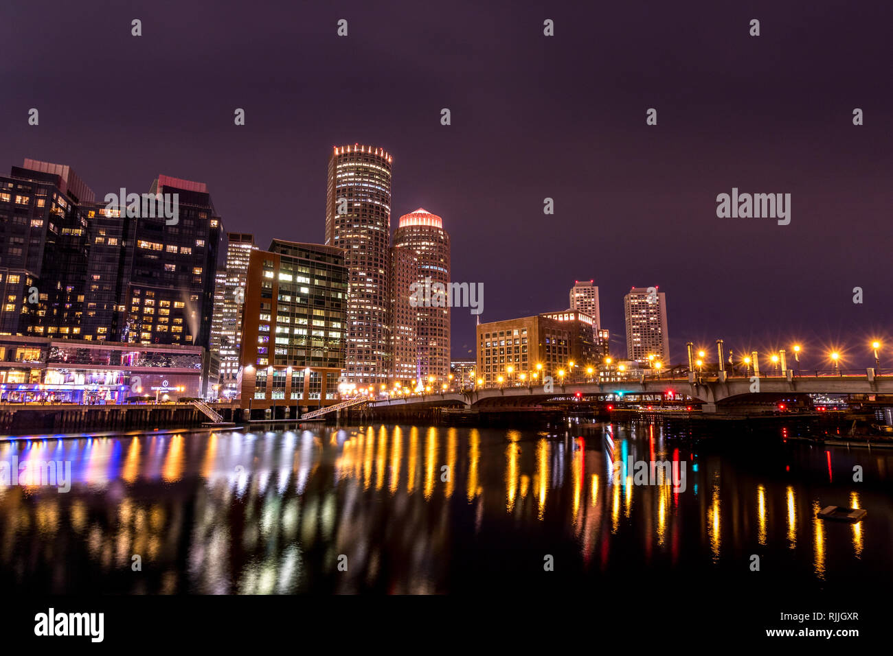 Night time view of Boston from across the Fort Point Channel taken with long exposure to high-lite the reflections in the water. Stock Photo