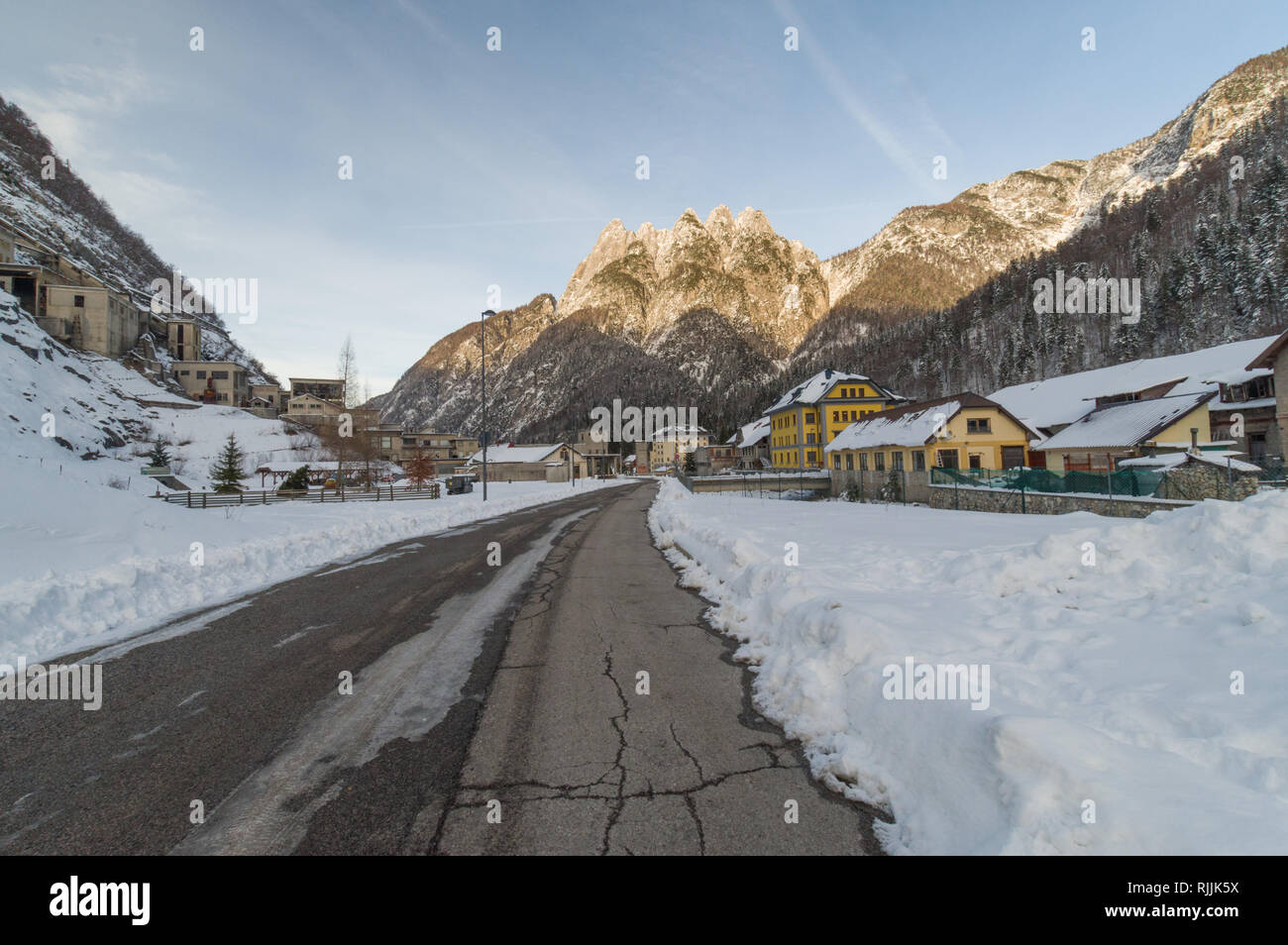 Cave del Predil, Italy (26th January 2019) - The snowy valley the alpine town of Cave del Predil with the old mine of zinc and lead on the left Stock Photo