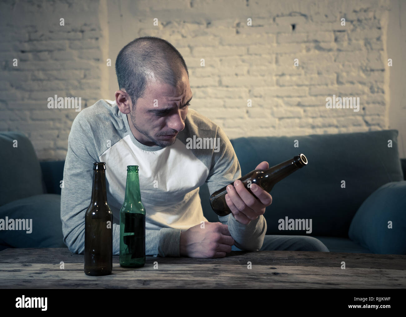 Young sad drunk men drinking beer and alcohol feeling wasted, lonely and desperate in pain and emotional stress. People and Alcohol abuse, addiction a Stock Photo