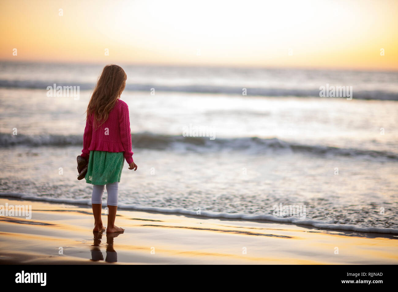 Little girl looking out at the ocean in excitement Stock Photo