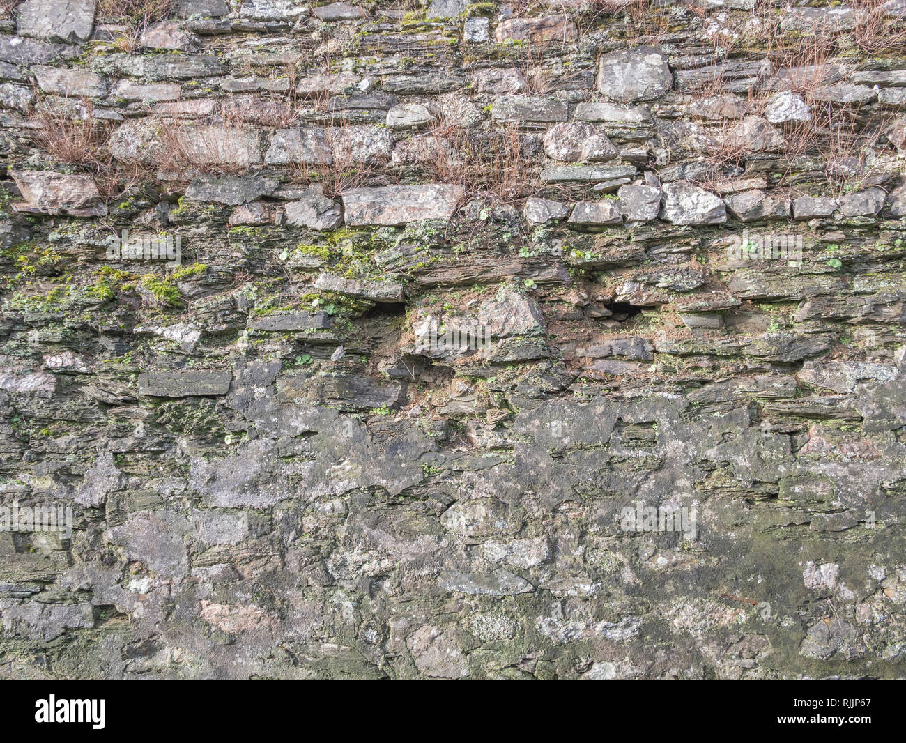 Old stone wall in a poor state. Stock Photo