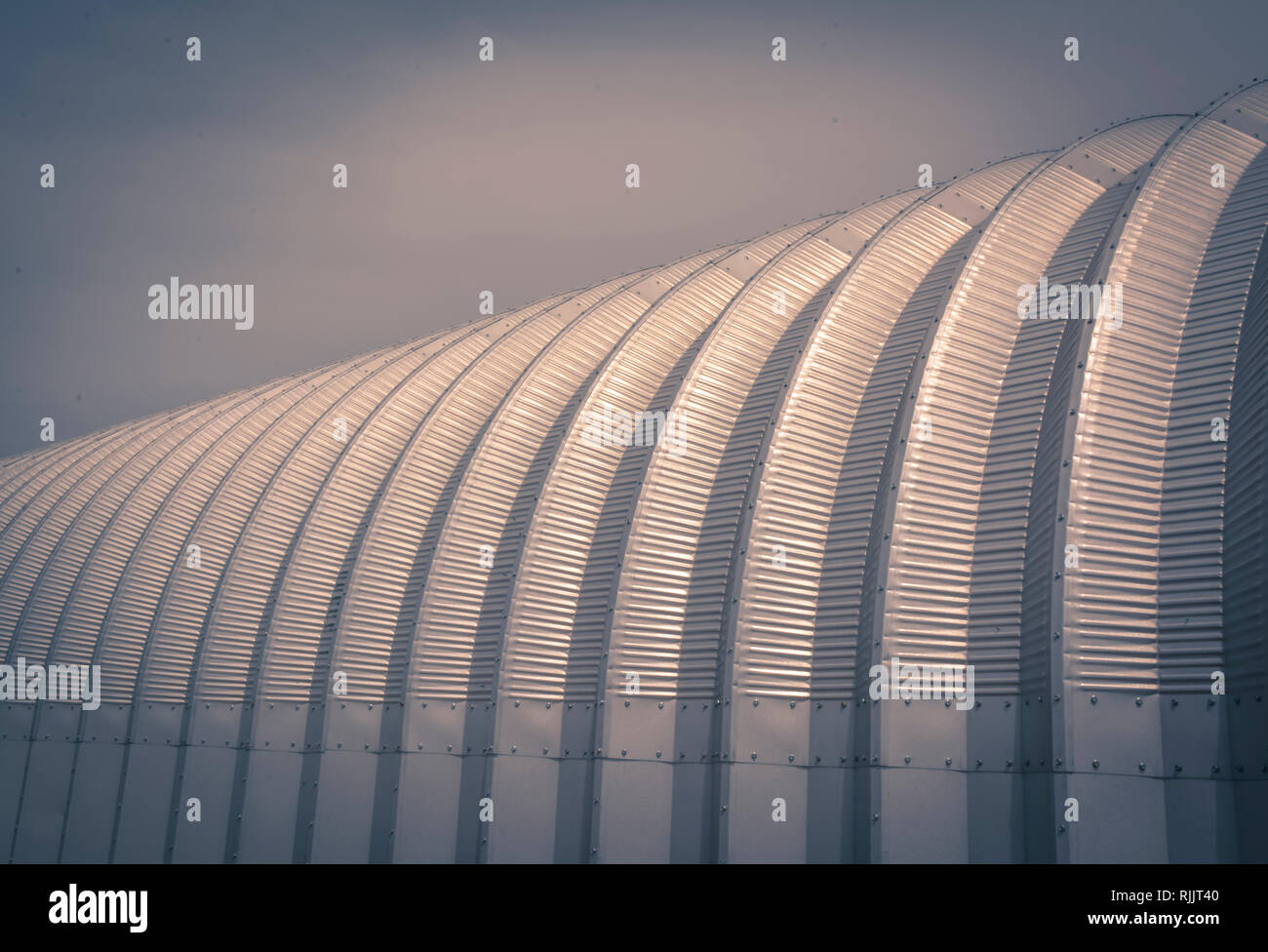 A conceptual background and artistic feeling to a close-up of a half round metal agricultural building outside of Amarillo TX Stock Photo
