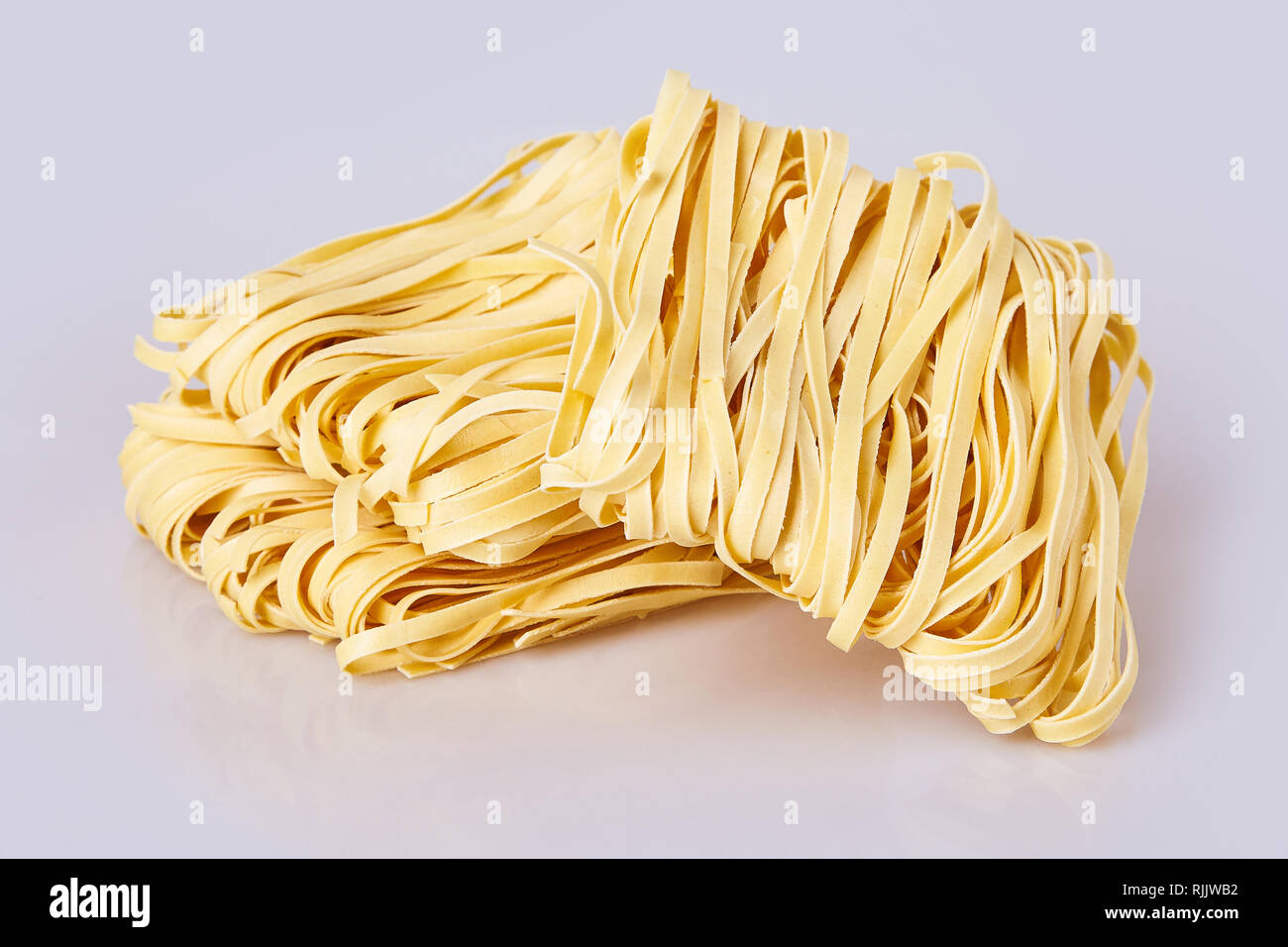 Dry thick rolled noodles square shape. Capelli d'angelo, Angel's hair - pasta.  Homemade italian pasta tagliatelle. Italian Cuisine. Egg noodles. Stock Photo