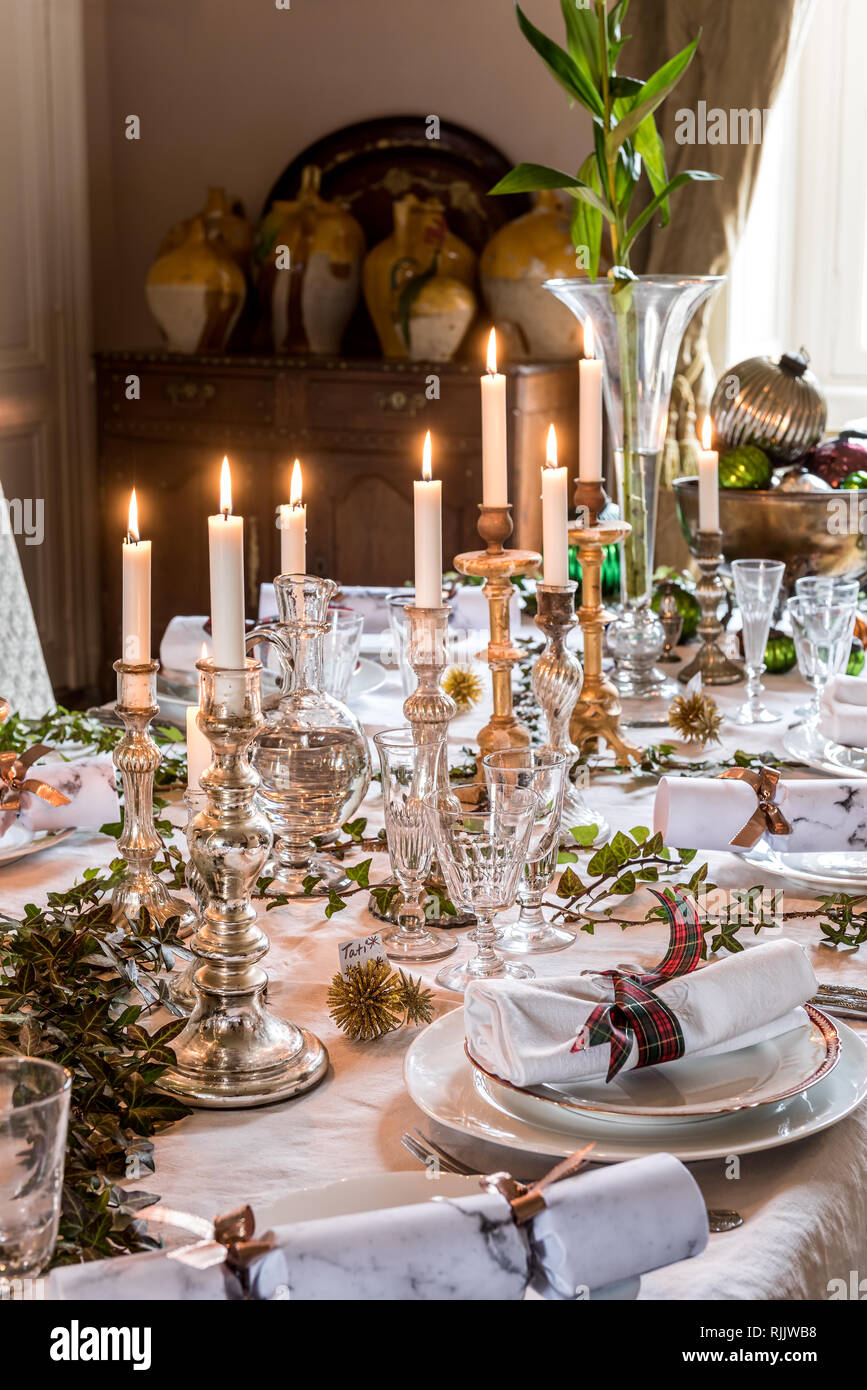 Mercury candlesticks on table set for Christmas dinner Stock Photo