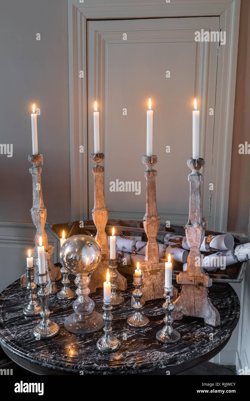 Carved wooden and silver candlesticks on 1840s marble topped table Stock Photo