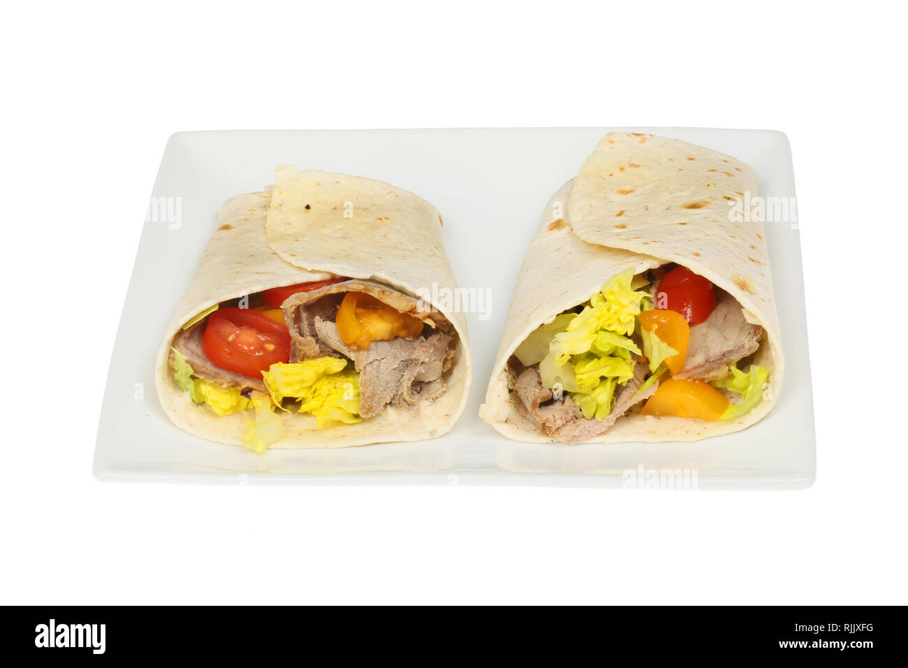 Beef, tomato and lettuce sandwich wraps on a plate isolated against white Stock Photo