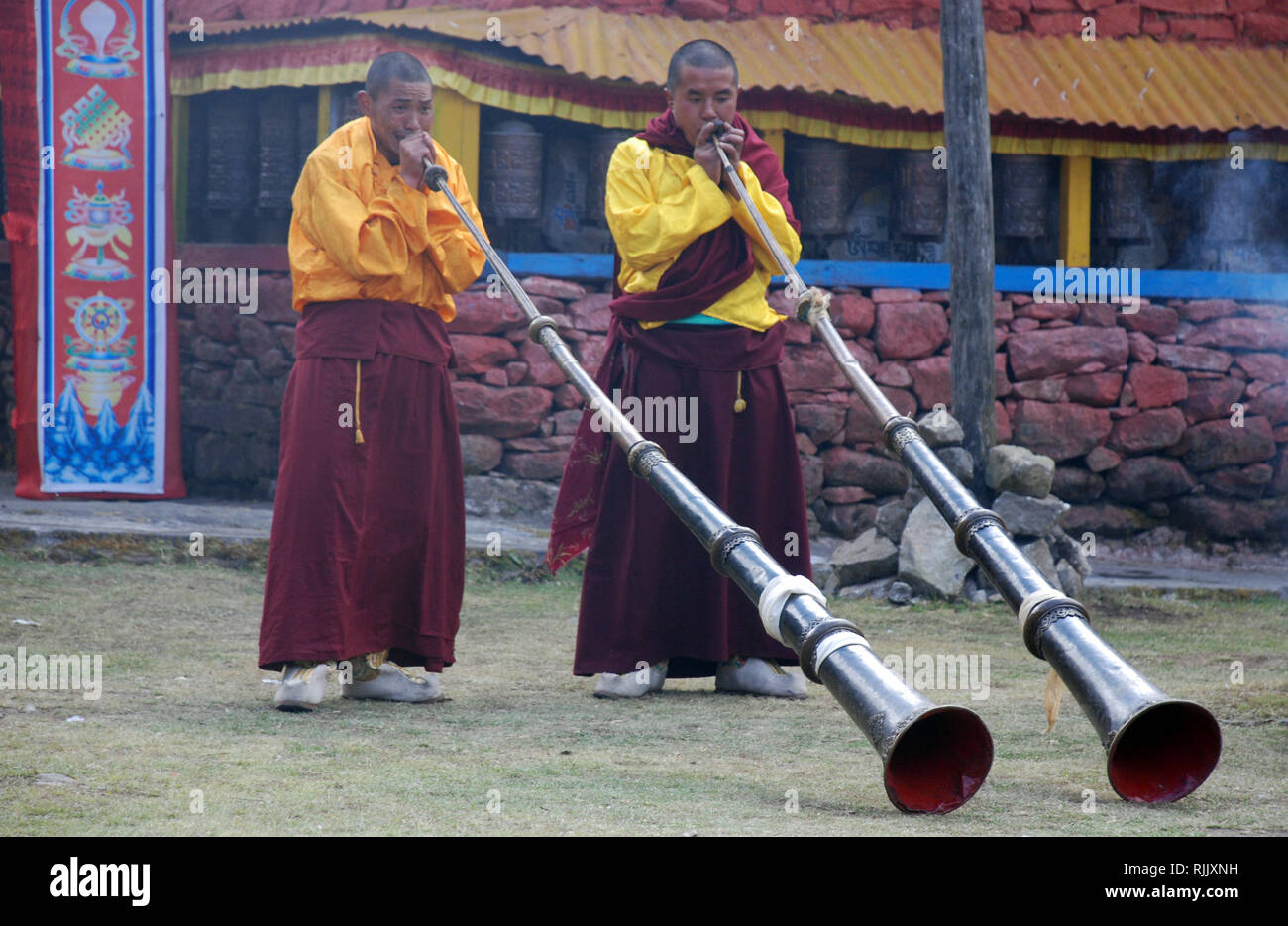 Buddhist monks play temple trumpets at the Monastery at Olangchung Gola in Nepal Stock Photo