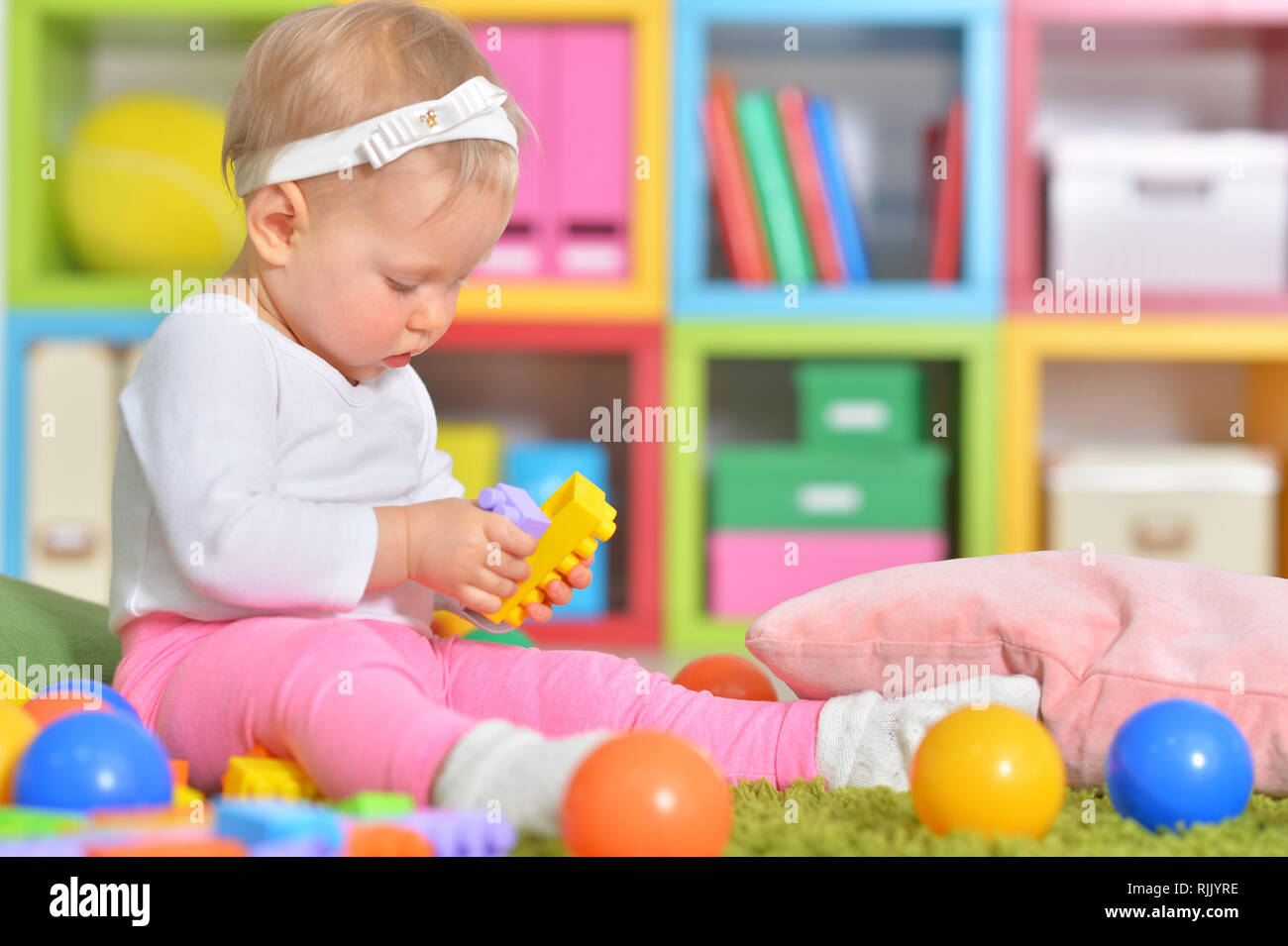 Portrait of little child playing with colorful toys Stock Photo - Alamy