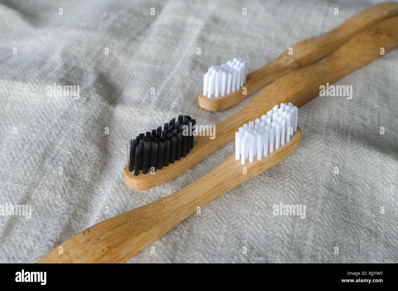 Three Bamboo toothbrushes on grey textile background Stock Photo