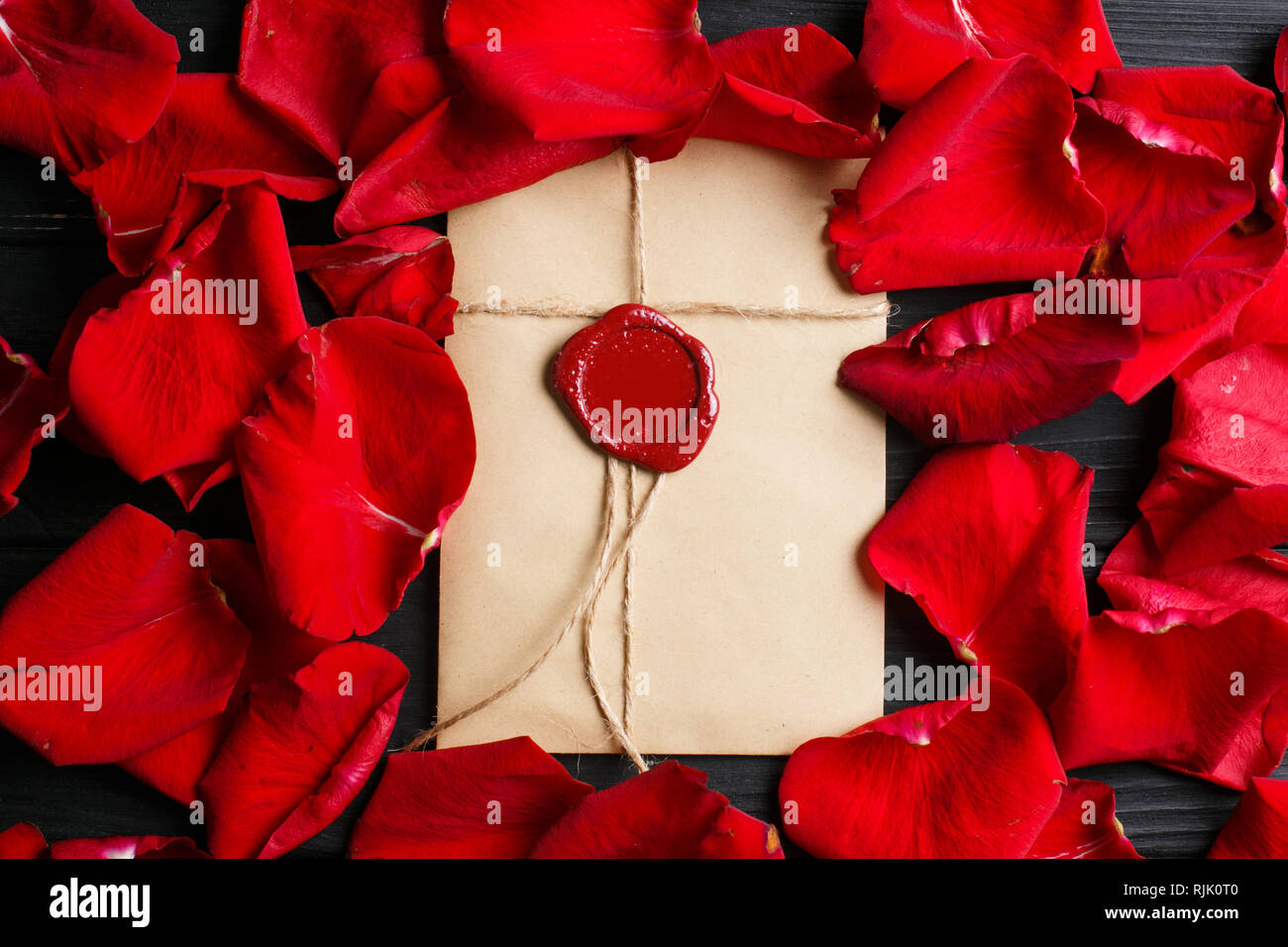 Envelope with wax seal with red rose flowers petals around Stock Photo ...